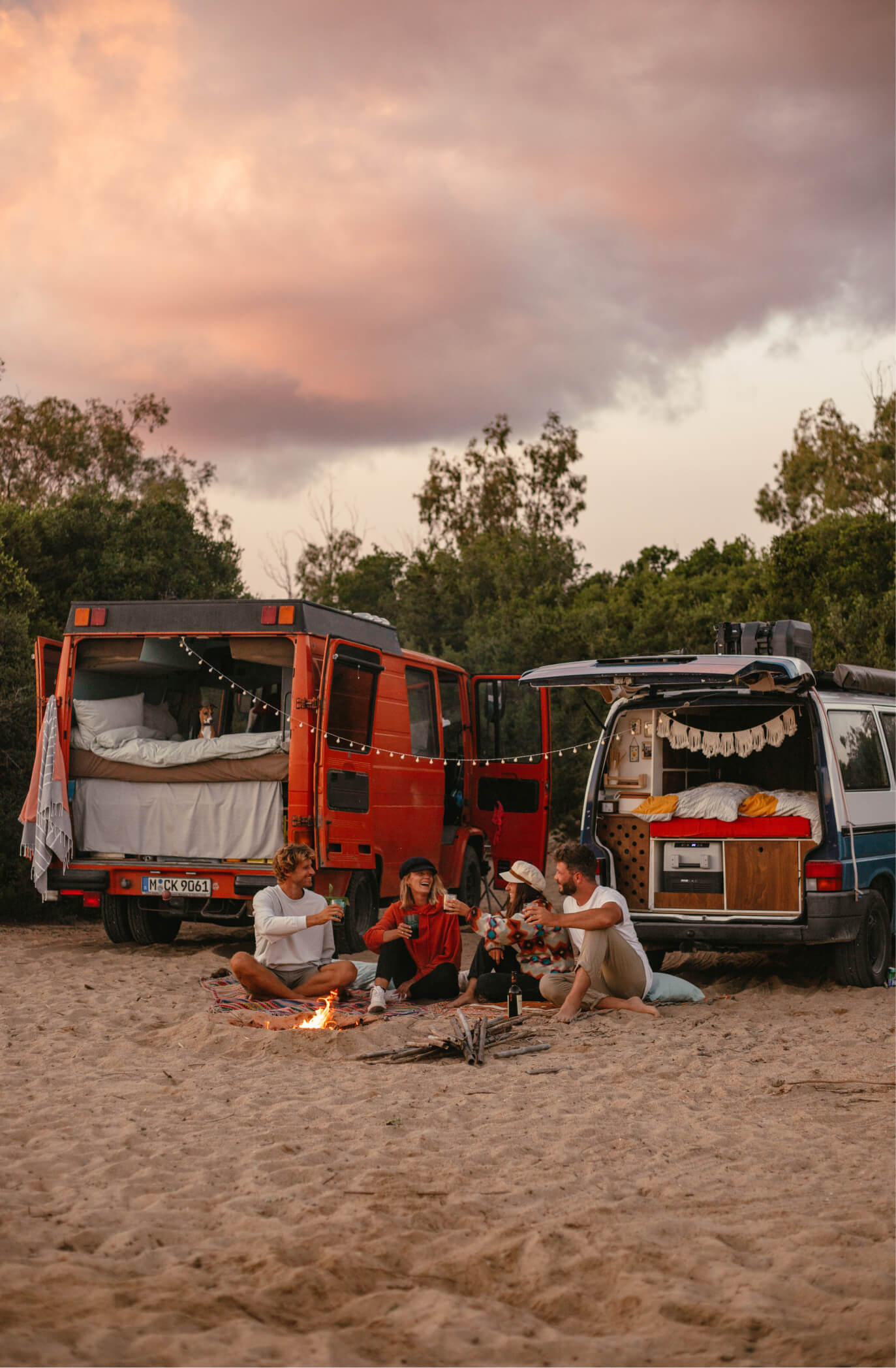 Sascha und Angie sitzen mit ihren Freunden Phil und Lui am Lagerfeuer, mit ihren Vans.