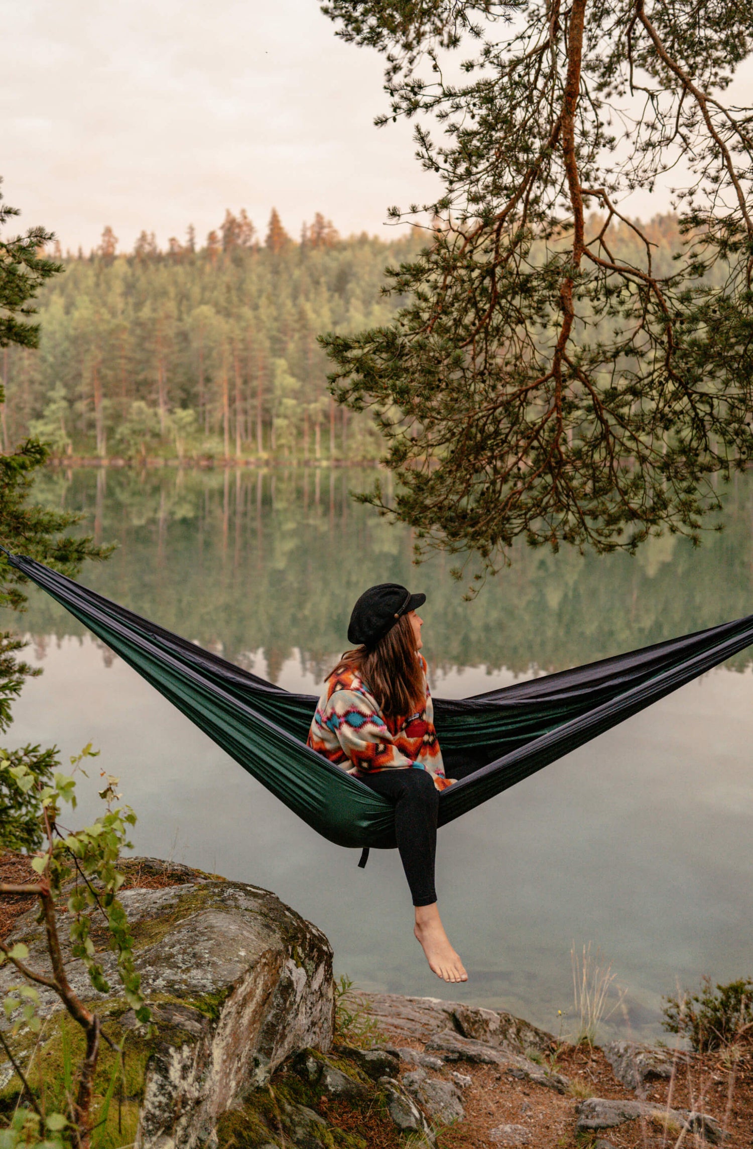 Angie sitzt in der Hängematte, an einem See in Schweden.