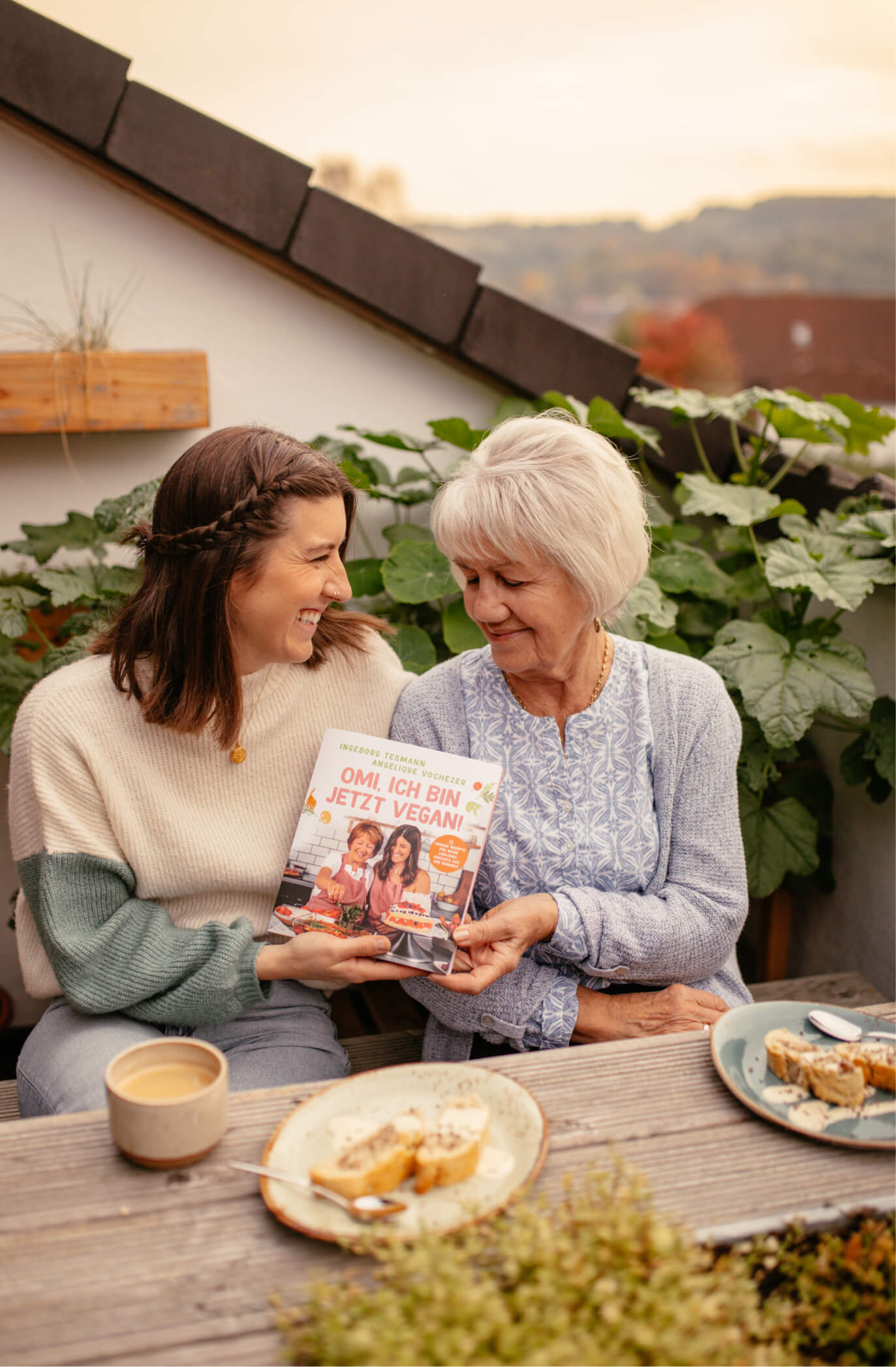 Angie und Omi auf der Terrasse mit ihrem Kochbuch "Omi, ich bin jetzt vegan!"