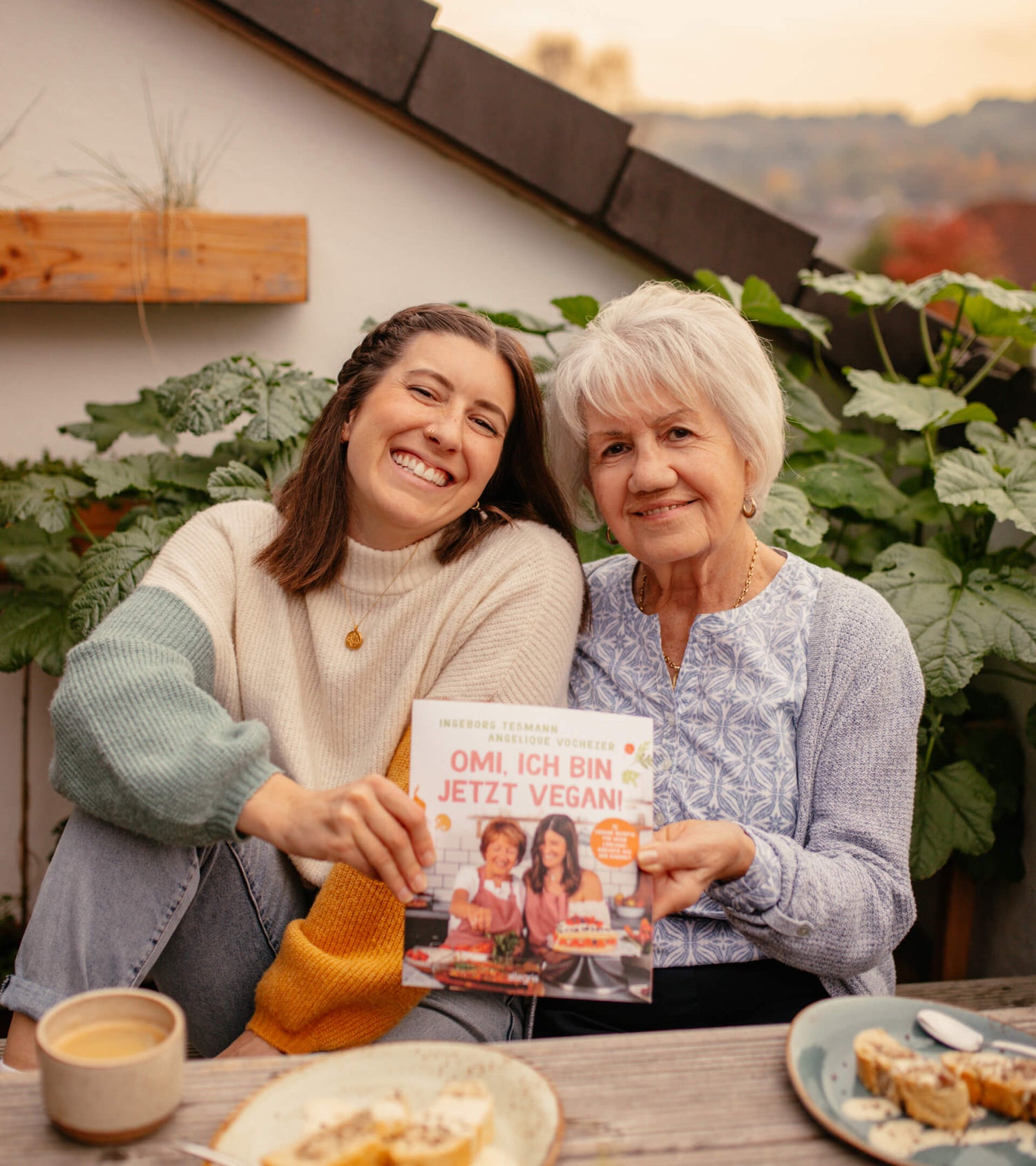 Angie und Omi auf der Terrasse mit ihrem Kochbuch "Omi, ich bin jetzt vegan!"