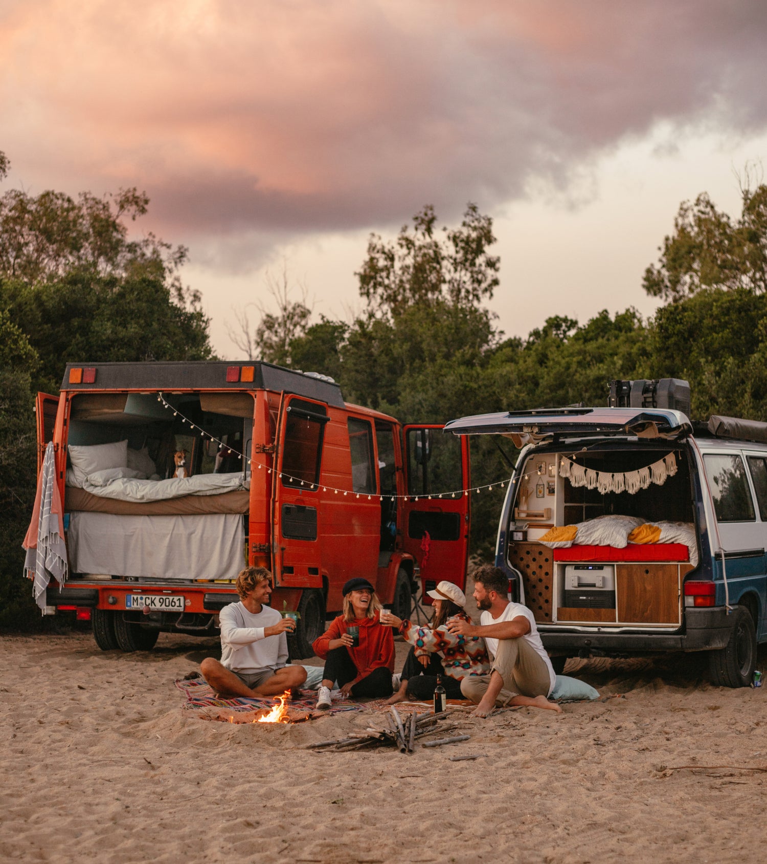 Sascha und Angie sitzen mit ihren Freunden Phil und Lui am Lagerfeuer, mit ihren Vans.
